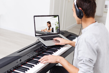 Profesor de piano dando clases virtuales a niño en Lima